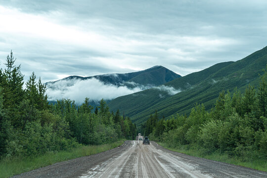 Dusty, muddy wet dirt road leading to Polebridge Montana from Glacier National Park on a rainy day