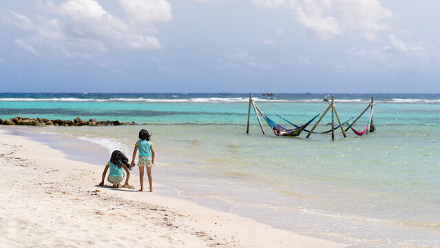 Dos ni&ntilde;as jugando en la playa de Mahahual M&eacute;xico hamacas dentro del mar