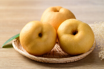 Asian pear or Nashi pear in basket on wooden background
