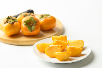 Sliced ripe persimmon fruit on plate 
