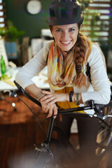 smiling elegant business woman in bike helmet in eco office
