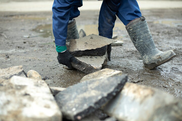 Worker lays stones. Cleaning of construction waste.