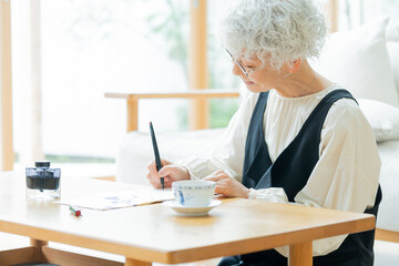 文字を書くシニア日本人女性