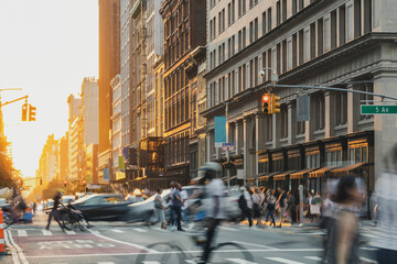 Crowds of people walking down the street at a busy intersection on 5th Avenue in New York City with light shining in the background