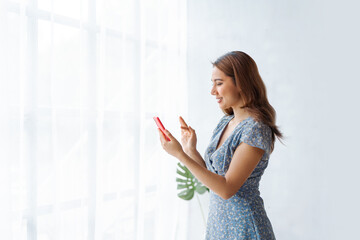 Young cheerful attractive pretty Indian woman using mobile phone.