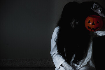 Woman ghost horror holding pumpkin above head in the building house, halloween concept