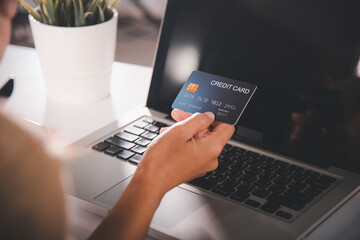 Online shopping. Woman hands holding credit card and using laptop with product purchase at home,...