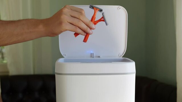 Used old dirty plastic disposable razors. Plastic pollution problem. Contactless Smart Touch Trash Can