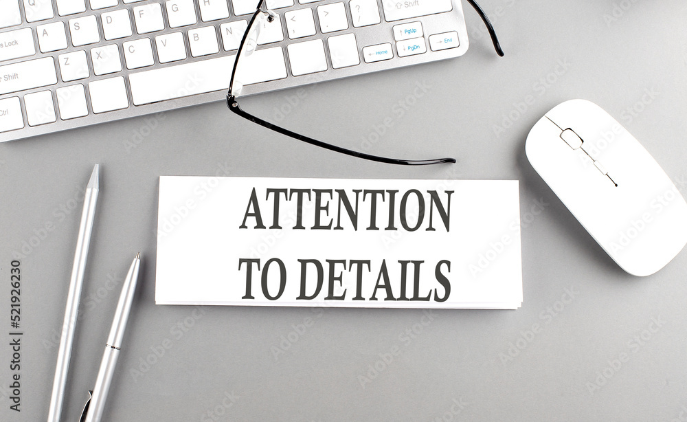 Poster attention to details text on paper with keyboard on grey background