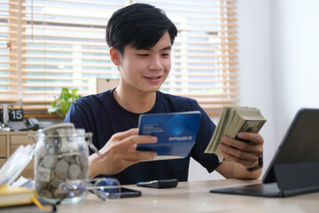 Man holding saving account passbook, calculating domestic bills and managing household expenses...