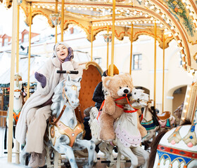 Pretty woman saddled a horse on a carousel.