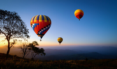 Colorful hot air balloons flying over mountain at sunset. adventure in summer vacation.