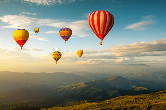 Colorful hot air balloons flying over mountain at sunset. adventure in summer vacation.