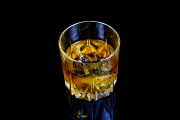 Glass of whiskey isolated on the black background