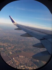 Fototapeta premium Airplane flying at an altitude with a view of land and trees.