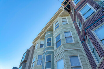 Three residential buildings in a row against the clear sky in San Francisco, CA