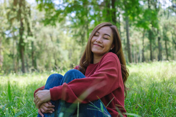 Portrait image of a young woman with closed eyes enjoying and relaxing in the park