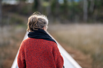 portrait of a woman walking in winter with a scarf, on a boardwalk in Berlin Europe 