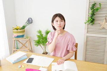 自宅で勉強中に考える女性