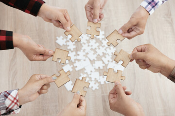 A group of business people assembling jigsaw puzzle. The concept of cooperation, teamwork, help and support in business. Team business success partnership.