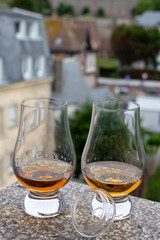 Two glasses of scotch whiskey with view on old houses on background, Edinburgh whisky tasting tour, Scotland