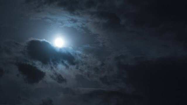 Night sky with full moon, clouds and stars. Timelapse. Clouds and moons moving across the sky. Atmospheric video