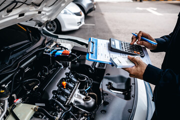 Mechanic calculates the cost of car repairs to customer at garage workshop, Car auto services and...