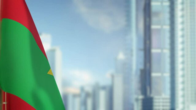 hanging Burkina Faso flag on city bg with blue sky