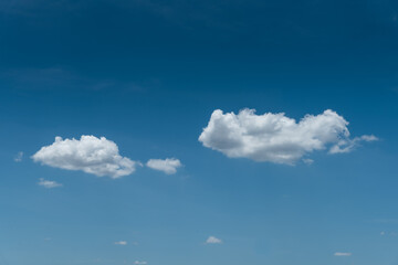 Minimalist clouds on deep blue clear sky background 