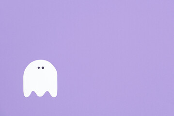 Trendy minimalist halloween background, white cute ghost isolated on lilac, pastel color design with copy space.