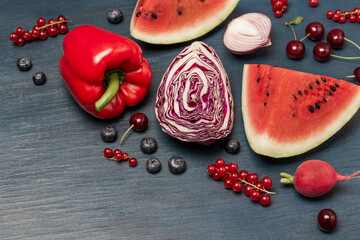 Piece of watermelon, half a cabbage, cherries, red currants on blue