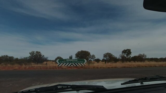 Looking through the windscreen of a car as it pulls up to T- intersection  in outback Australia