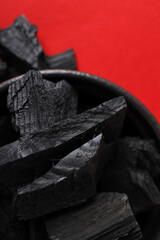 Natural hard wood charcoal on red background