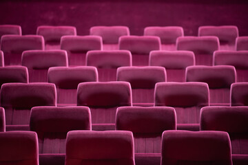 Empty red chairs for audience in the theater