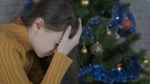Teen Christmas holiday in loneliness. A young girl with negative feeling stay in the Christmas room.