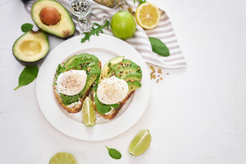 Freshly made poached egg and Avocado toasts on light grey background