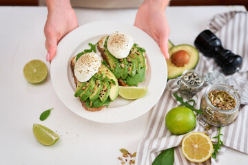 Freshly made poached egg and Avocado toasts on light grey background