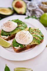 Freshly made poached egg and Avocado toasts on light grey background