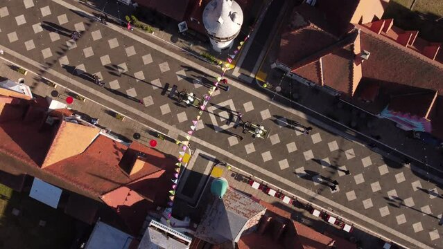 Festivity on main street of old medieval town of Republica de Los Niños in Argentina. Aerial ascending top down pov