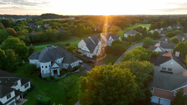 Mansions in American neighborhood community. Private gated community with golf course views. Dramatic sunlight. Aerial view. Retirement, wealth management theme.