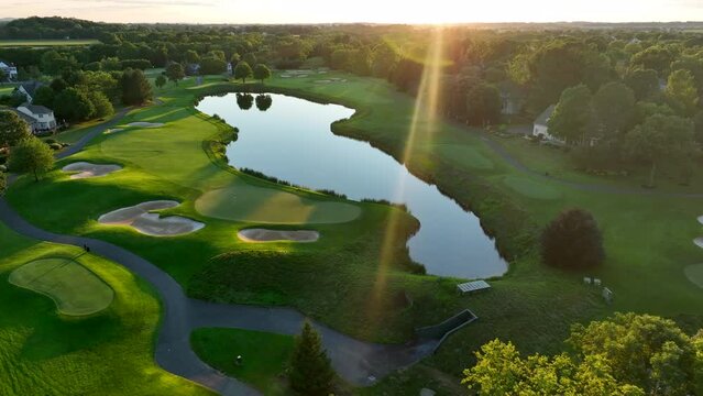 Beautiful Aerial Of Golf Course Country Club Water Hazard, Sand Trap, Fairway Green With Reflection Of Sun.