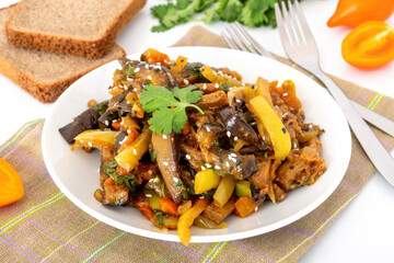 Vegetable stir fry in asian style on white dish. Cooked pepper, eggplant and tomato served with bread. Healthy vegetarian meal.