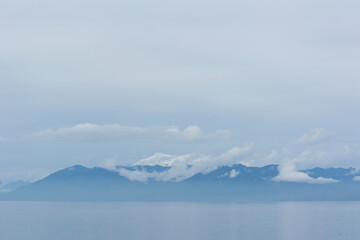 Montañas sobre el mar con nubes