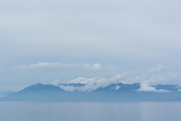 Montañas sobre el mar con nubes