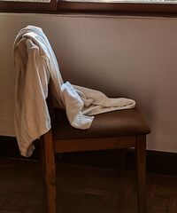 A chair with a white towel draped over it.