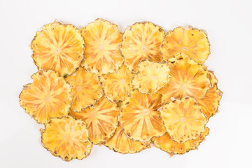many slices of dried pineapple on a light background