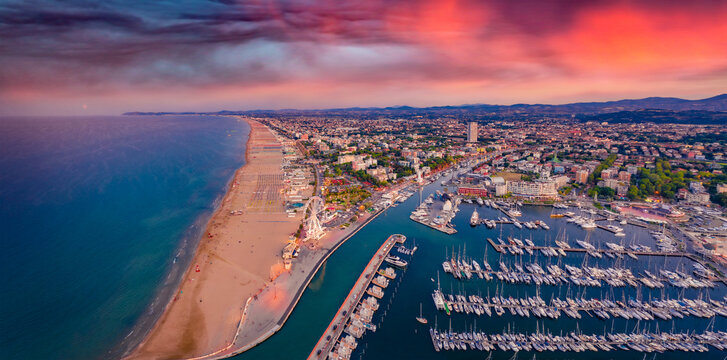 Panoramic summer view from flying drone of Libera Rimini public beach. Incredible evening scene of Italy, Europe. Spectacular sunset on Adriatic coast. Vacation concept background.