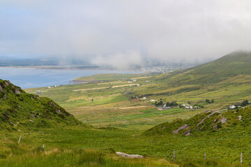 Fototapeta na wymiar Irish coastline with mountains and low hanging clouds