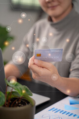 Close up shot of females  hands holding credit card typing message on laptop for shopping online with technology icons.