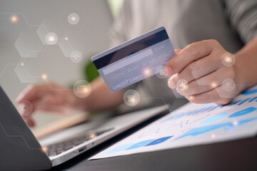 Close up shot of females  hands holding credit card typing message on laptop for shopping online with technology icons.